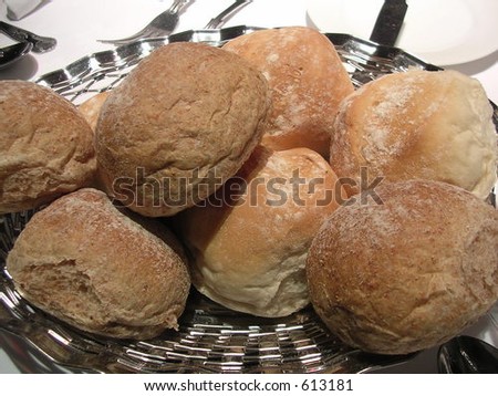 Bread.Brown and White Bread Rolls in a silver serving dish.