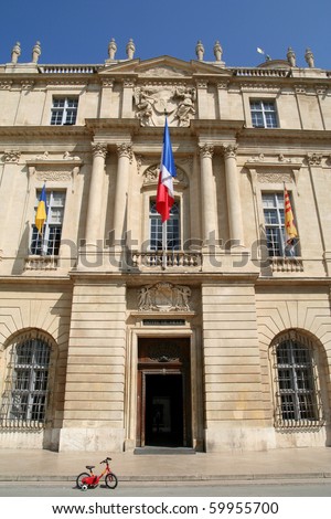 The Mayors office in Arles, France, with a childs tricycle out front.