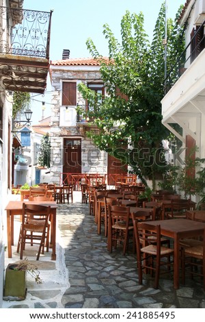 Empty tables of a backstreet restaurant in the early morning in Skiathos,, Greece. A laid back, relaxed atmosphere is encouraged.