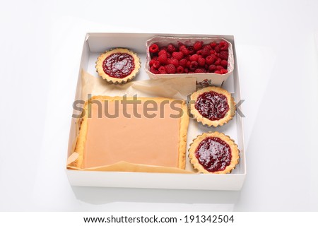 Cakes in a box and raspberries