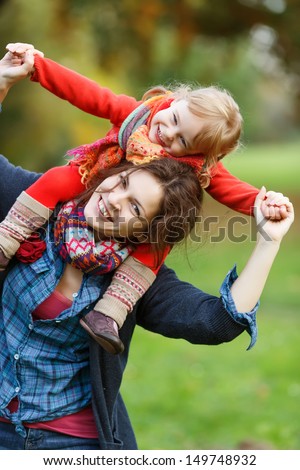 Little girl and her mother in the autumn park