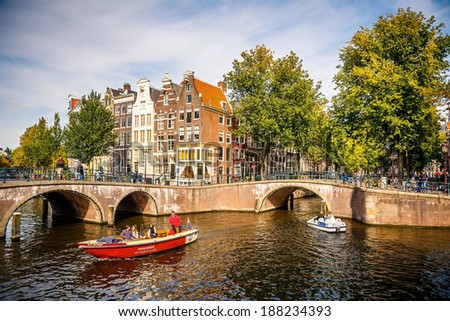 AMSTERDAM - SEPTEMBER 30, 2012: Boats on the canals in Amsterdam, Netherlands. Construction of the canal system started in Amsterdam in 1613 proceeding from west to east.
