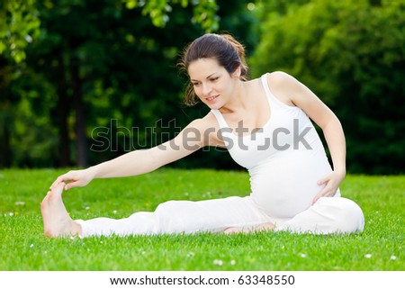 Beautiful pregnant woman practicing in the park