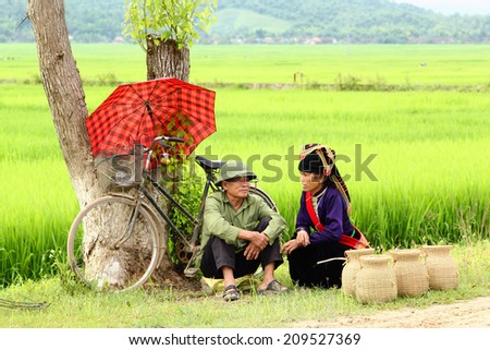 Dien Bien Phu, Dien Bien, Vietnam August 6, 2014: Two farmers sitting sells handcrafted items beside a road.