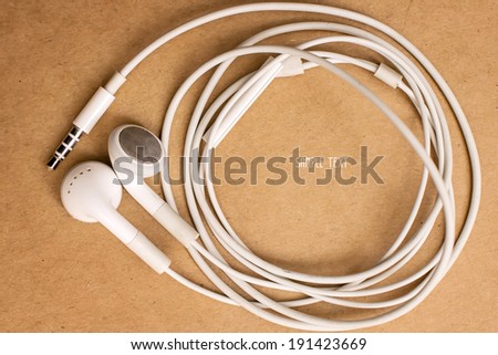 white earphone on paper background and sample text