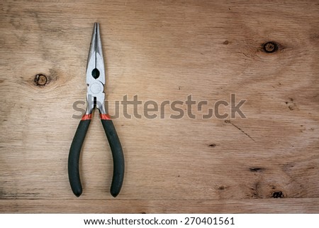 Old pliers, Old pliers on brown wooden background in rustic style.