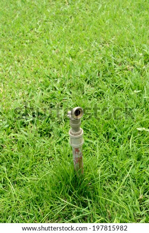 Old  pipe of the water work system on the grass.