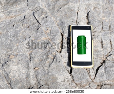 Full battery of mobile phone on stone background.