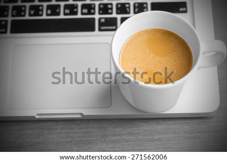Hot latte coffee cup and laptop on Black and White background