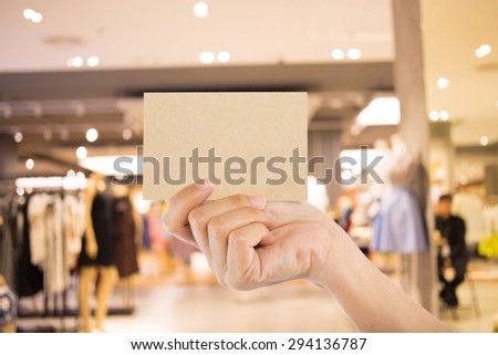 Hand hold blank business card in the shopping mall.