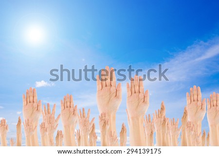 Diverse Raised Hands on sky background
