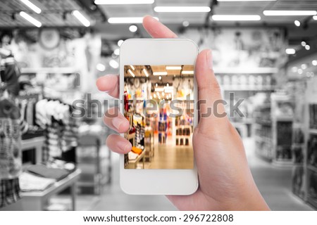 Women in shopping mall using mobile phone.