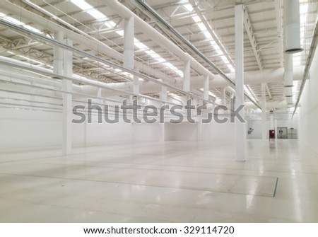 Blurred of White empty industrial warehouse or plant space