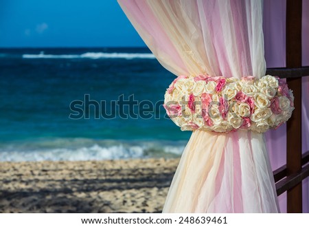 View of beautiful flowers at beach alter framing the ocean for a destination wedding.