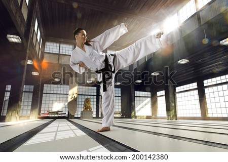 Karate woman in action on light  old sports hall