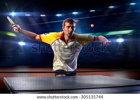 young sports man tennis player is playing on black background with lights