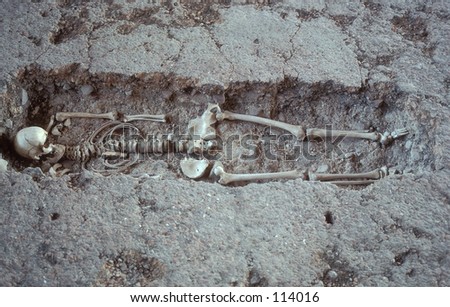 Ancient human skeleton in shallow grave.