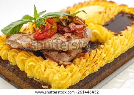 Meat steak surrounded with cake of mashed potatoes, studio shot