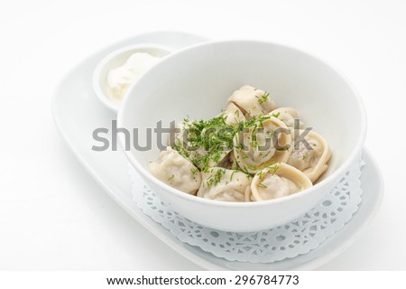 Russian traditional dish ravioli with sour cream isolated on white