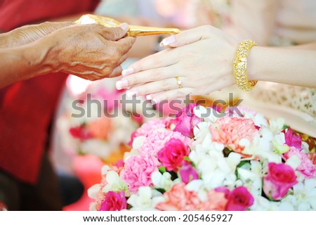 hands pouring blessing water into bride\'s bands, Thai wedding