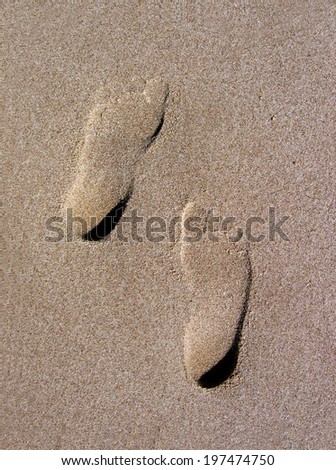 Imprints of two feet in the desert sand.