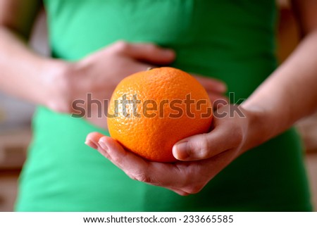 hand holding nice orange, give yourself one and enjoy it and have a better health.