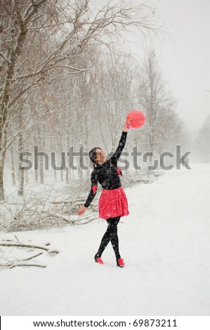 The girl in the winter with red air balloon