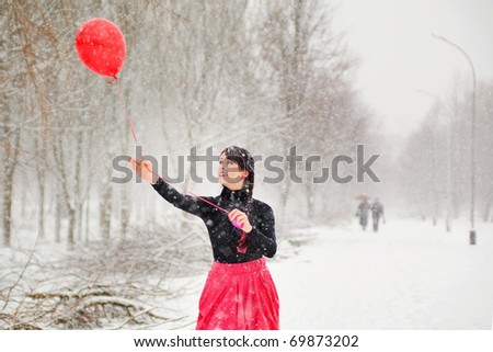 The girl in the winter with red air balloon