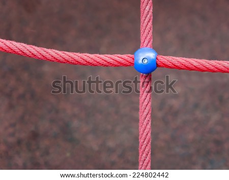 Red rope cross with blue connector in the middle