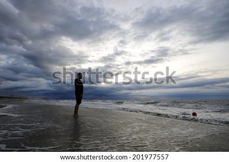 Lonely man in a beach before the storm