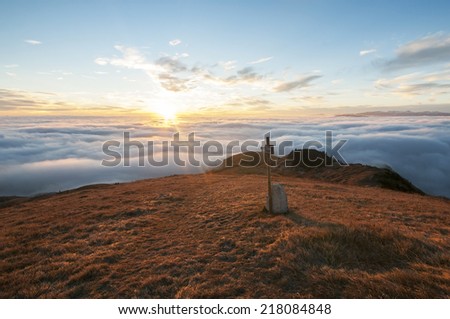 On top of the mountain,sunset light emerges from clouds