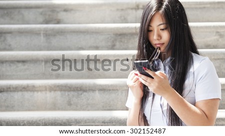 Young Asian women watch videos with mobile phones