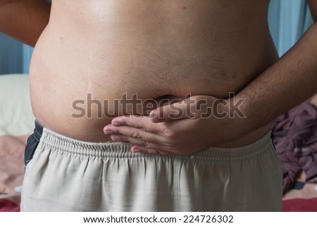 Man grabbing his fat on the stomach