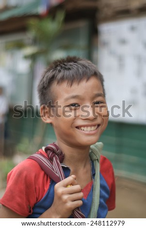 Mae Hong Son, Thailand - August 03, 2010: An unidentified Burmese refugee boy on the way back home from school in Mae La Ma Luang temporary shelter in Mae Hong Son, Thailand