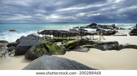 Beautiful landscape beach with rocky shore and dramatic clouds, Noosa Heads, Sunshine Coast, Australia