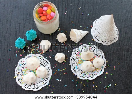 Meringue cakes out of the egg white and sugar white lacy napkin on a black table in the New Year and Christmas decorations