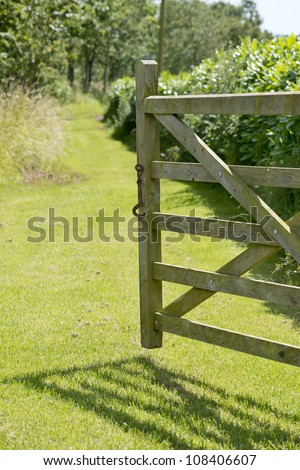 Open gate to grass pathway on a summers day.