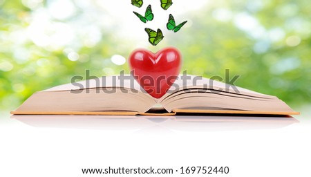 The book of love, a book open with a heart in the middle isolated on a green spring background
