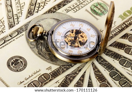 Macro shot of pocket watch face with 100 dollar bill Ben Franklin.