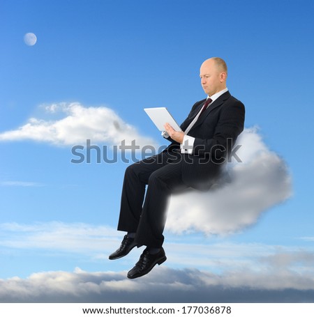 a businessman sitting on a cloud with a tablet pc