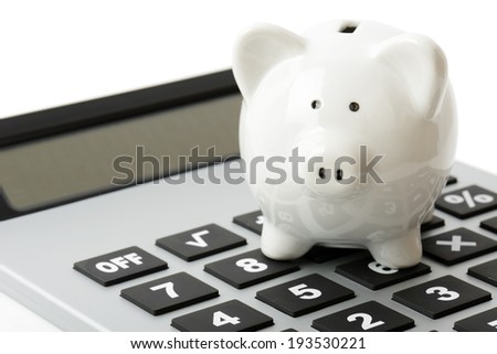 a white piggy bank on top of a calculator a white piggy bank on top of a calculator