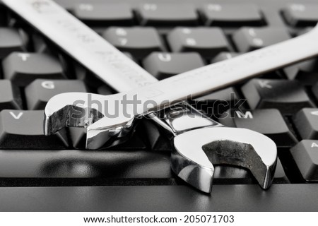 Concept for it assistance with a computer problem, spanners on a computer keyboard.