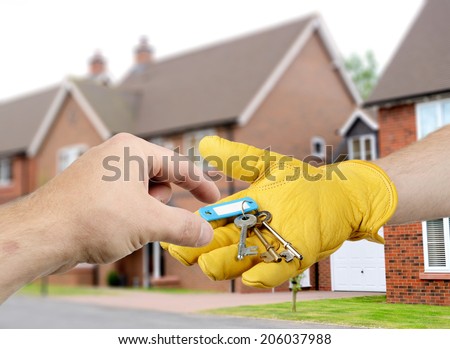 a builder handing the keys to a new house to a new home owner
