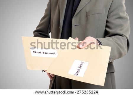 man in a suit showing two envelopes one with good news and one with bad