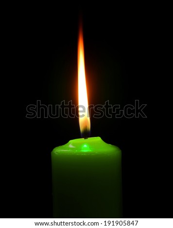 green candle on black background