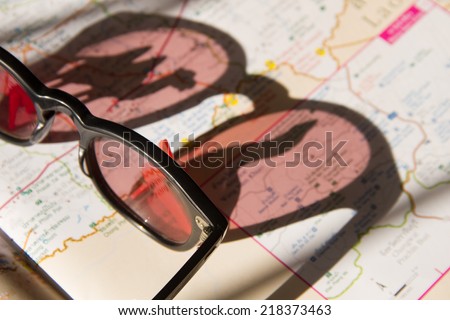 Sunglasses with the shadow of camel and lion sea on the map