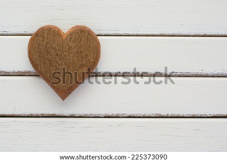 Photo of a wood heart on top of an old white wood background.