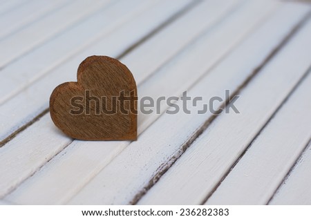 Photo of a wood heart on top of an old white wood background