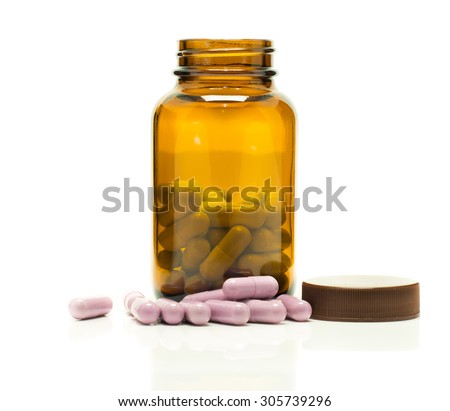 Tea colored medicine bottle with some tablets vitamins isolated on white