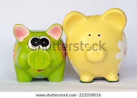 Green and yellow ceramic piggy banks with flowers posing
